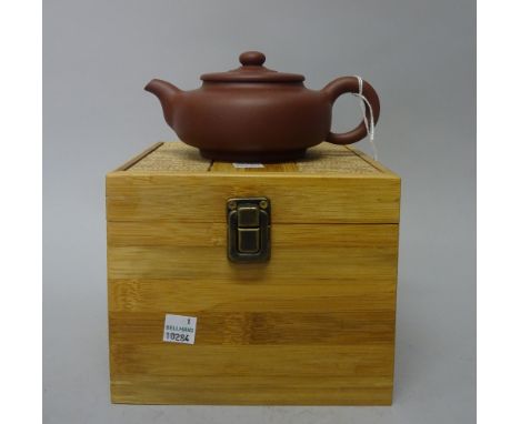 A Chinese Yixing stoneware teapot and cover, 20th century, of compressed globular form with button knop, signed, 7.75cm. high