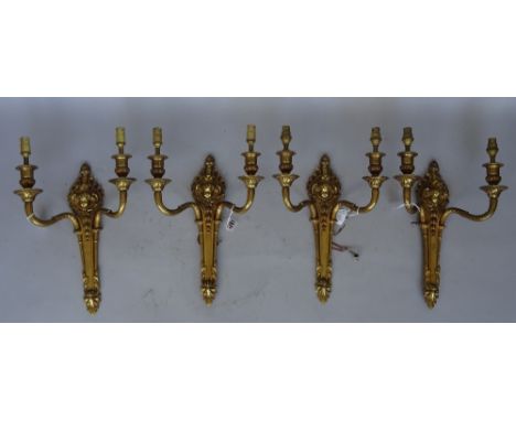 A set of four Louis XVI style gilt brass two branch wall appliques, early 20th century, each relief cast with cherub portrait
