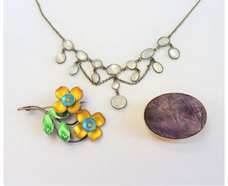 A gold mounted carved amethyst quartz oval brooch, with foliate decoration, detailed to the pin K 14, a vary coloured enamel 