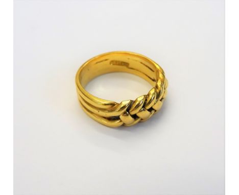 A gold keeper ring, in an interwoven design, detailed 18 C, ring size M, weight 7.1 gms.