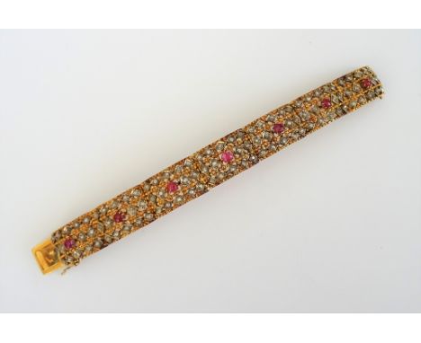 A gold, ruby and diamond bracelet, formed as a row of curved rectangular panel shaped links, each centred by a cabochon ruby 