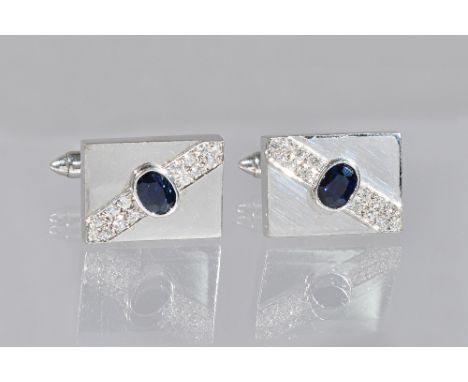 A pair of white gold, sapphire and diamond rectangular cufflinks, each collet set with an oval cut sapphire to the centre, be