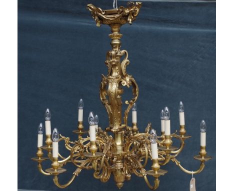 A French ormolu twelve light chandelier, Louis XVI style, the reeded stem with ornate foliate embellishments issuing twelve b