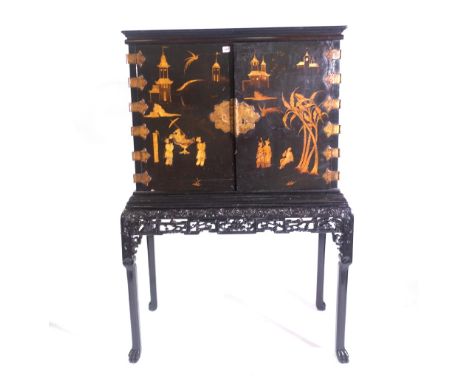 An Edwardian chinoiserie japanned cabinet-on-stand, incorporating 18th century Japanese lacquer doors, the exterior decorated