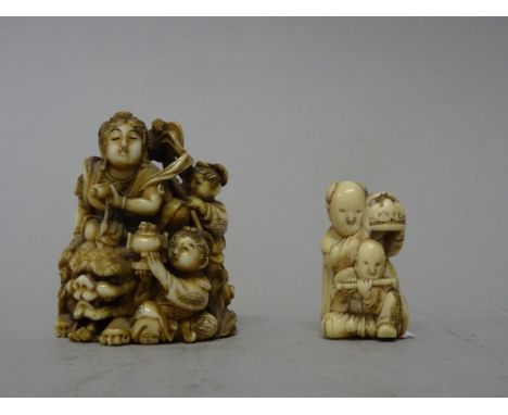 A Japanese ivory netsuke, Meiji period, carved as a woman seated on the back of a recumbent shishi, two young attendants at h