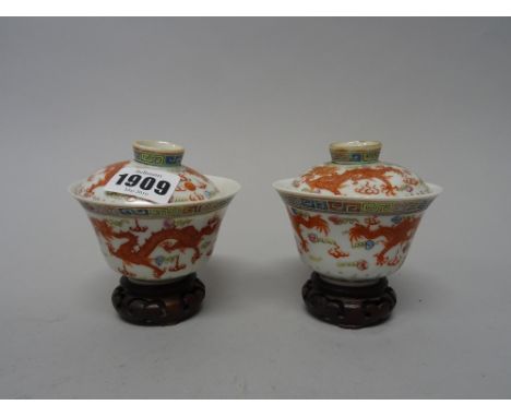 A pair of Chinese famille-rose cups and covers, late 19th/20th century, each piece painted with two iron-red dragons chasing 