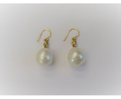 A pair of cultured pearl and diamond pendant earrings, each with a large cultured pearl to the drop and with a circular cut d
