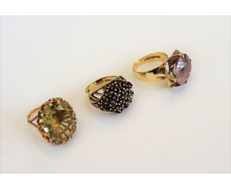 A 9ct gold ring, claw set with a circular cut amethyst, a 9ct gold ring, claw set with an oval cut citrine and a 9ct gold and