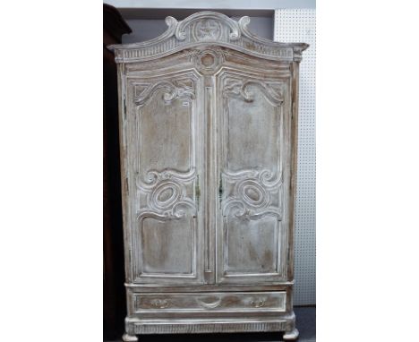 A 19th century limed oak armoire, with pair of shaped double panel doors, over single drawer, on splayed canted bracket feet,