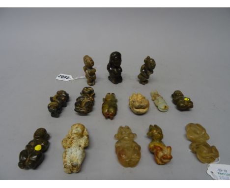 A group of twelve jade and two rock crystal figures, various colours, mostly carved in a squatting pose, sizes 5cm. to 7cm., 