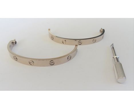 A Cartier 18ct white gold love pattern bangle, of twin section form, detailed Cartier 750 EPE306, weight 37.2 gms, with an ac