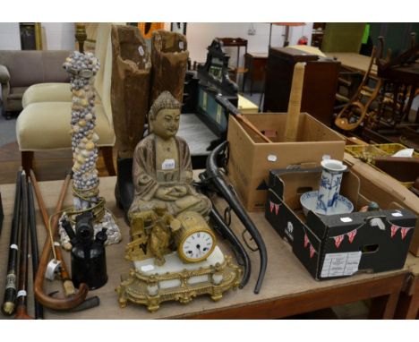 A carved wooden Buddha, striking gilt metal mantel clock, table lamp, two papier mache mannequin legs with cast iron shoes, S