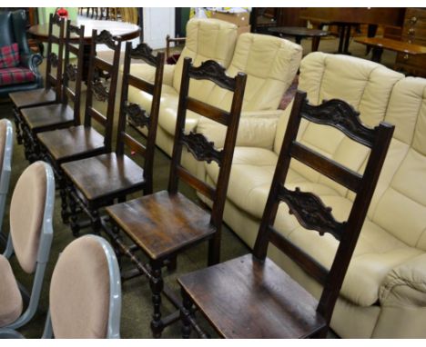 A set of six oak ladder back dining chairs, with solid seats and foliate carved back and top rail 