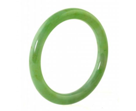 A CHINESE JADEITE BANGLE  of milky green hue with   apple green inclusions and OFfine polish, 9cm diam ++In fine condition