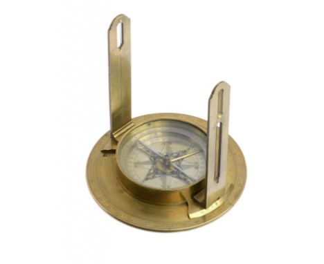 AN ENGLISH BRASS SURVEYOR'S COMPASS, MID 19TH C  with engraved scale and detachable sights, the silvered compass box with jew