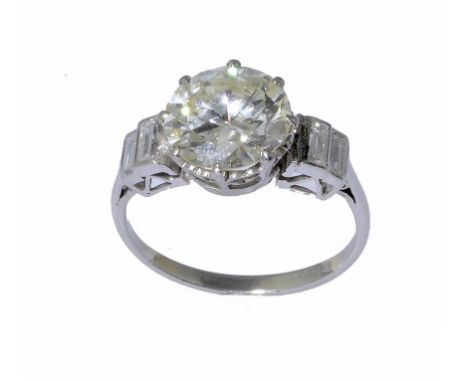 A DIAMOND RING  with a round brilliant cut diamond and baguette diamonds to the shoulders, in platinum, marked PLAT,  3.3g gr