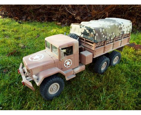 An RC controlled military truck with power bank and flashing lights. In US army desert livery and mock canvas cargo area.16cm