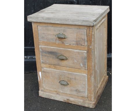 A late 19thC stripped light oak pedestal cabinet, the rounded overhanging top raised above three drawers on an overhanging ba