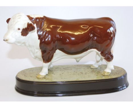 A Beswick model of a cow, on ceramic plinth, numbered to underside 2, 23cm long.