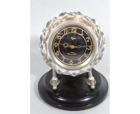 A Majakussi 11 jewel mantel clock, in Perspex case, with 10cm dia. Arabic dial on a plastic stand with hand wind movement.