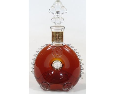 A Louis XIII glass Remy Martin Cognac decanter, the doughnut shaped body with raised moulding and fleur-de-lys style stopper,