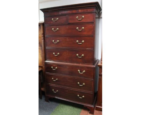 A George III mahogany chest on chest, with overhanging cornice set with stylised dentils, the upper section with two short an
