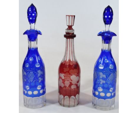 A pair of early 20thC Bohemian blue flash glass decanters, each with shaped stoppers and lipped neck, the shouldered body wit