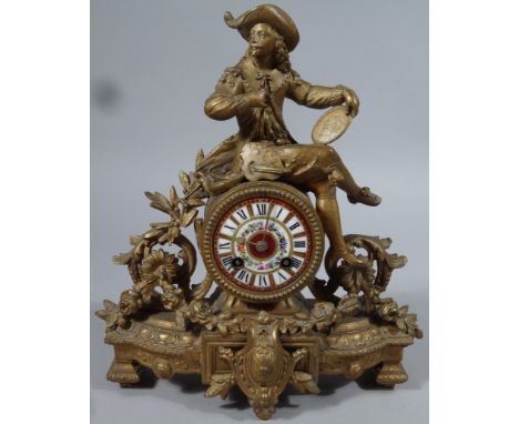 A late 19thC/early 20thC gilt metal mantel clock, surmounted by a classical French figure aside leaves and foliage and seated