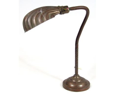 A mid-20thC Aesthetic period cast metal table lamp, with adjustable turned stem and shell shaped shade on stepped circular ba