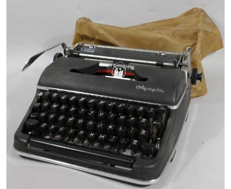 A bygone Olympia typewriter, with articulated keys, with cover, 30cm wide.