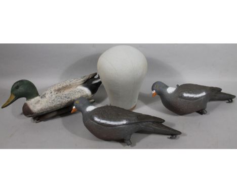 Two plastic decoy pigeons and a decoy duck, with weighted base, 39cm wide, and an embroidered mannequin head. (4)