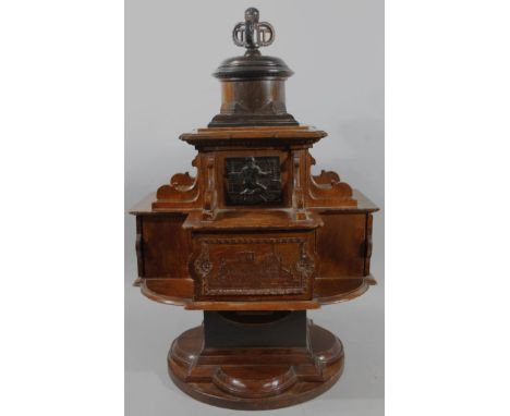 An early 20thC oak ebonised and mahogany rotating smoking casket, relating to Winchester cathedral, the intricate body with p