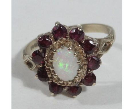 A 9ct gold floral cluster dress ring, set with garnets and opal, on pierced shoulders, 3.7g all in. 