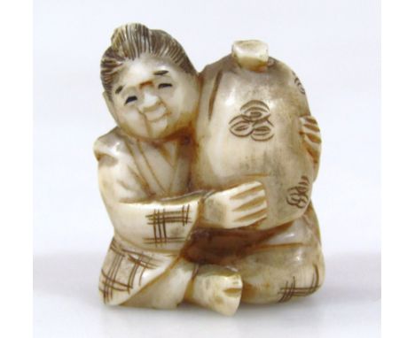 A Japanese carved ivory netsuke, of a seated woman holding a sack, 2.7cm long. (Taisho period 1912-1926) Provenance: Part of 