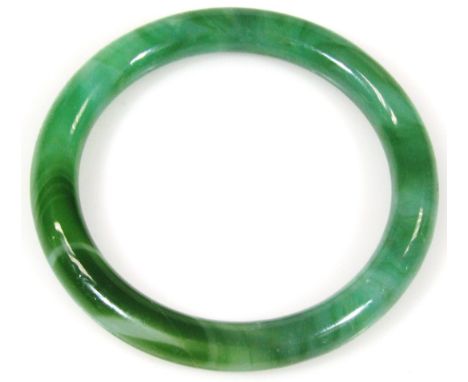 A 20thC Peking glass bangle, of polished plain outline, with flecks of colour predominantly in dark and light green, 8cm dia.