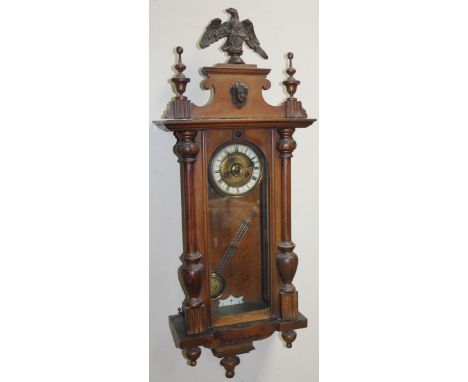 A late 19thC walnut cased Vienna wall clock, with 13cm dia. Roman numeric dial revealing an eight day pendulum swing movement