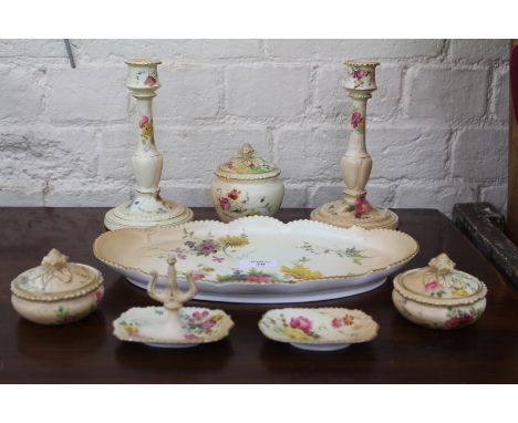 A ROYAL WORCESTER BLUSH IVORY PORCELAIN DRESSING TABLE SET to include a pair of candlesticks, jars and covers, a tray etc all