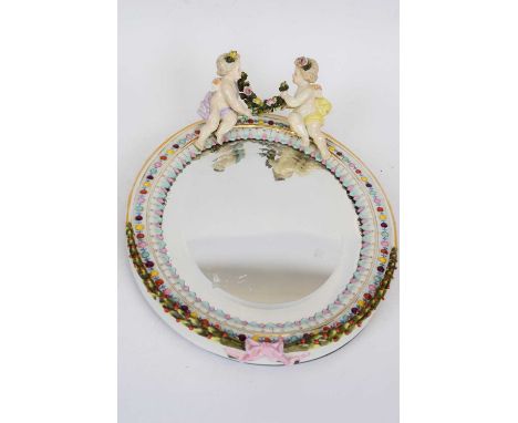 Sitzendorf porcelain oval mirror with white ceramic frame, surmounted by two cherubs, 30cm long