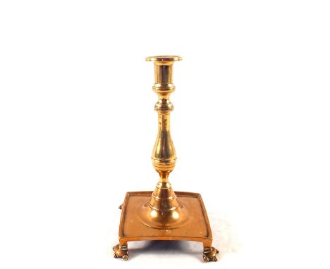 An early 18th Century Spanish Brass candlestick with wide square base on four ornate feet, 10 1/4" high