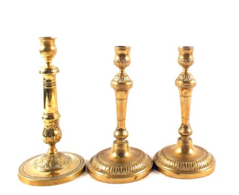 A pair of decorative 18th Century French seamed Brass candlesticks on wide circular bases, 10" high plus a similar single sea