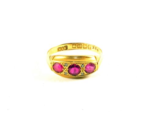 An 18ct Gold three stone Ruby ring set with small Diamonds, size O 1/2