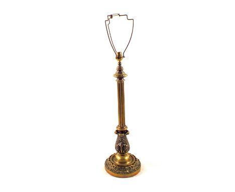 A large early 20th Century Brass table lamp with fluted and ornately cast decoration on wide circular base, 19" high to exclu