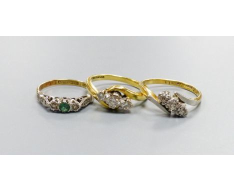   Two 18ct and three stone diamond set crossover rings, sizes K and N and an 18ct &amp; plat, emerald and diamond set three s