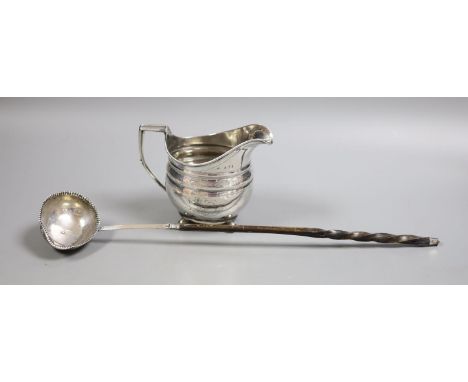   A George III silver cream jug, marks rubbed, height 10.7cm, and a 19th century toddy ladle.