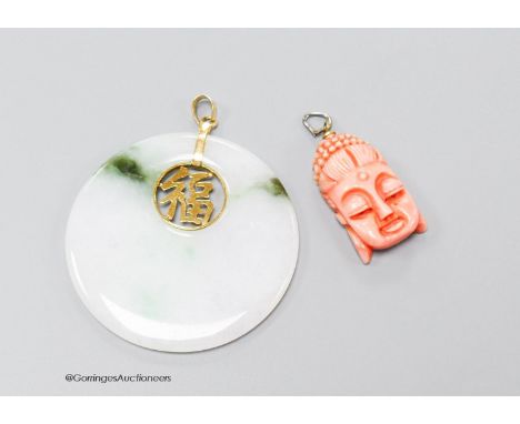   A Chinese jade disc pendant with inset yellow metal character and 14k bale, 46mm, and a carved coral mask pendant, 26mm.