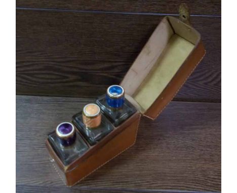 ENAMEL-TOPPED SCENT BOTTLES 
in a fitted leather case
Some chips to the enamel tops
