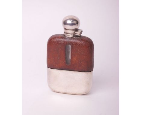 A clear glass hip flask with leather mounts and a plated hinged screw cover and removable cup, 14.5cm high overall.
