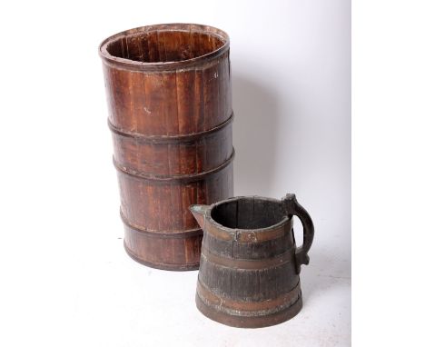 A coopered cylindrical stick stand, probably 19th century (h.64cm) and a large coopered jug with brass fittings (h.34cm)