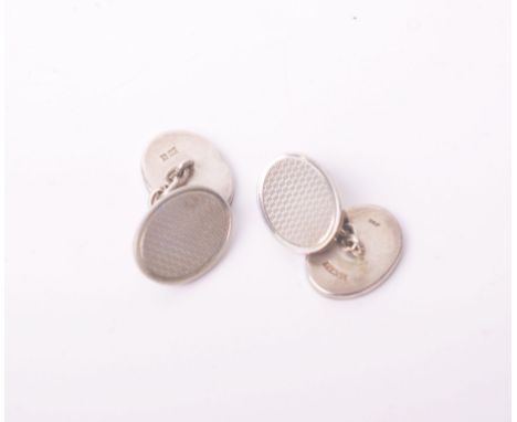 A pair of silver oval engine-turned &amp; plain oval twin-panel cufflinks with chain inter-links, Birmingham 1972
