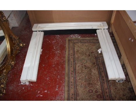 A part Carrara marble fire surround (dismantled and in four sections) with deep moulded mantle shelf with canted corners (unf
